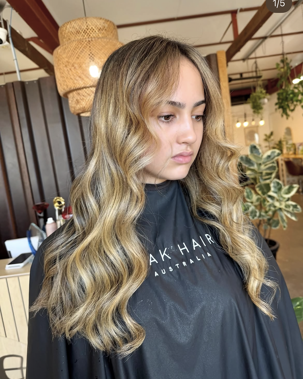 Warm brunette colour melt with caramel ribbons and loose waves, showcasing low-maintenance dimensional hair colour for Winter 2026.