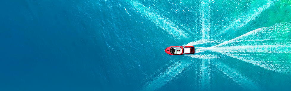 Boat travelling through water making ripples in the shape of the Union Jack flag