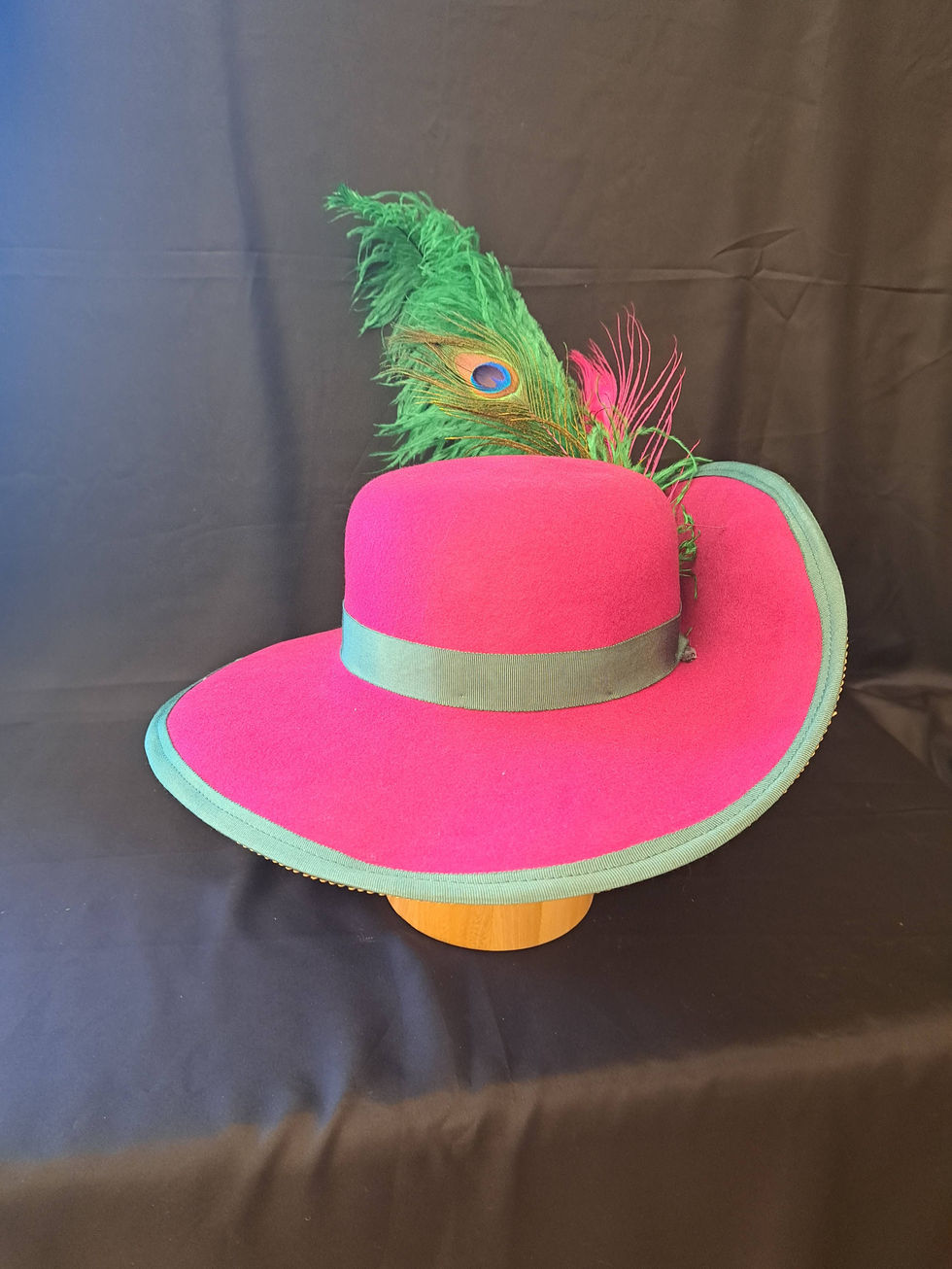 Hot pink cavalier hat with a green ostrich feather (front)