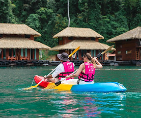 Guests kayaking beside floating villas at The Greenery Panvaree Floating Resort