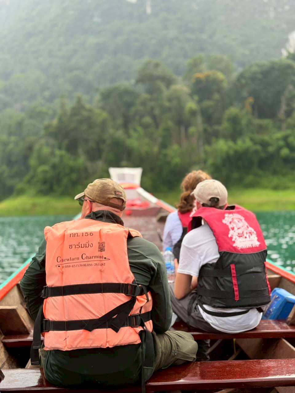 Private longtail boat cruising across Cheow Lan Lake surrounded by limestone mountains