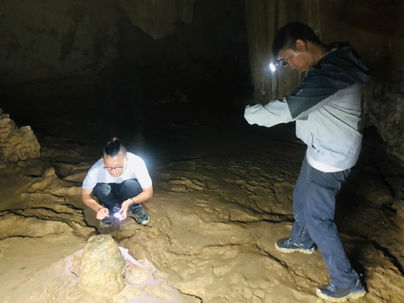 Traveler exploring the hidden limestone chambers and formations inside Coral Cave at Cheow Lan Lake.