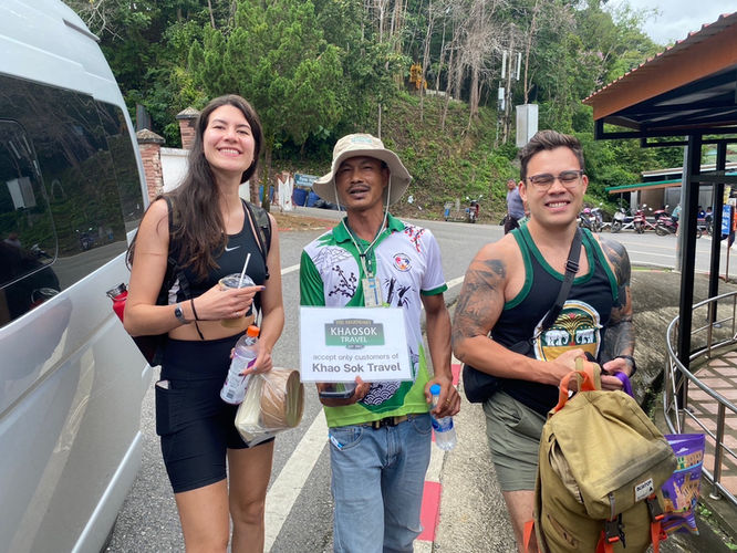 Happy travelers arriving at Cheow Lan Lake Pier before beginning a private jungle and lake adventure in Khao Sok National Park.
