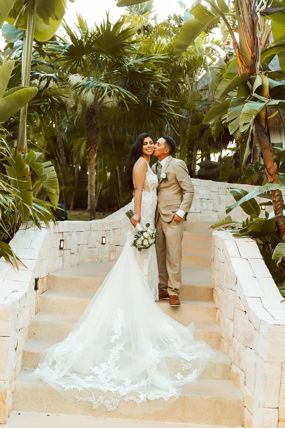 Destination wedding couple surrounded by tropical greenery in Riviera Maya