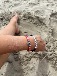 pied dans le sable et bras et bracelet colorés plein de sable joli
