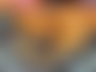 Close-up of bright orange hairy fungi growing on a mossy log among fallen beech leaves in autumn woodland.