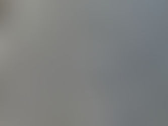 Close-up photograph of frost on a teak table, showing icy texture and dark swirling wood grain in natural morning light.