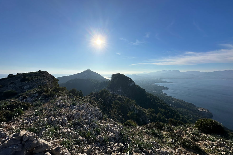 Mountain ridge above Alcúdia in Mallorca with the sun high in a clear blue sky