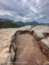A small rain pool reflects dramatic Tramuntana peaks on the GR221 – a highlight for hikers