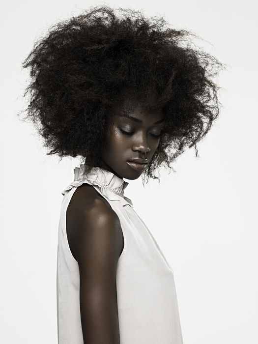 Beautyshot einer dunkelhäutigen Frau mit aufgelockertem Afro Haarstil