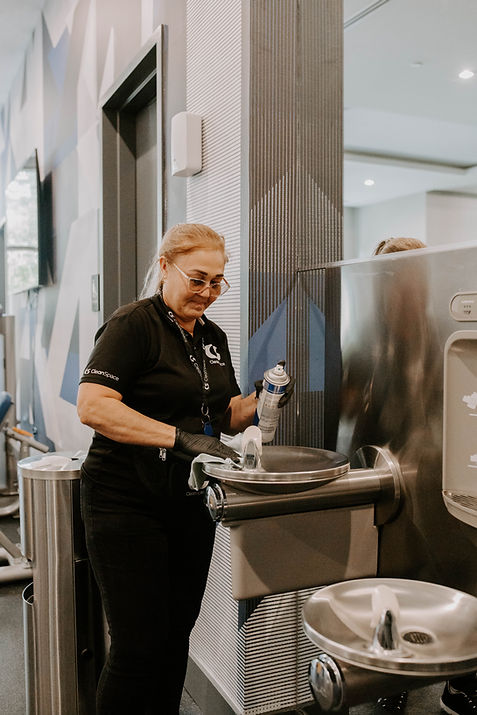 Clean Space staff member disinfecting a hotel restroom sink in a guest facility