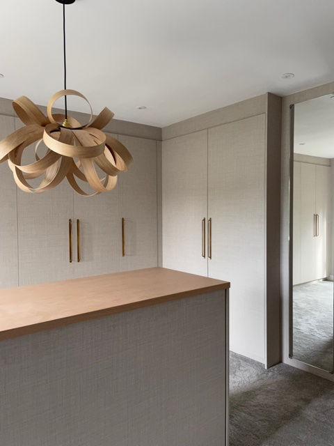 a kitchen with a wooden pendant light hanging from the ceiling
