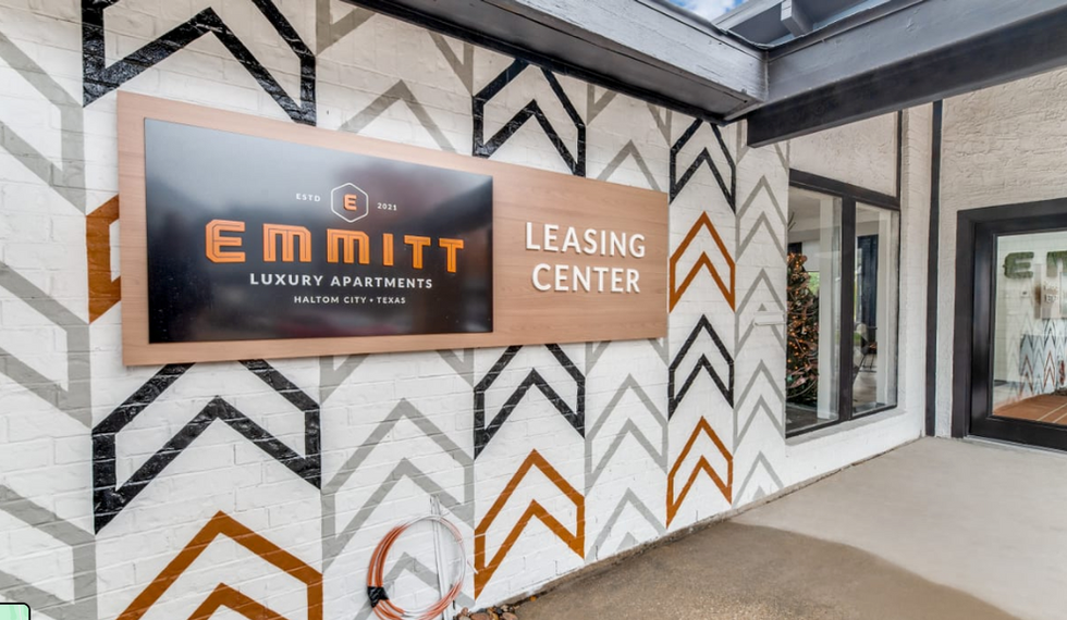 Emmitt leasing center wall signage with large logo and directional arrow on patterned facade