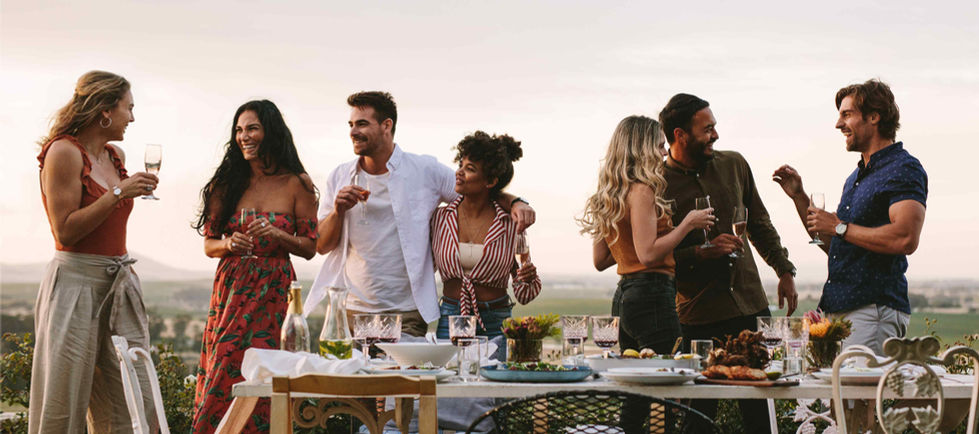 Group of people gathered outdoors enjoying food and drinks in lifestyle setting