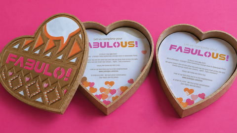 Open heart-shaped box that reads "FABULO" with valentines inside the box.