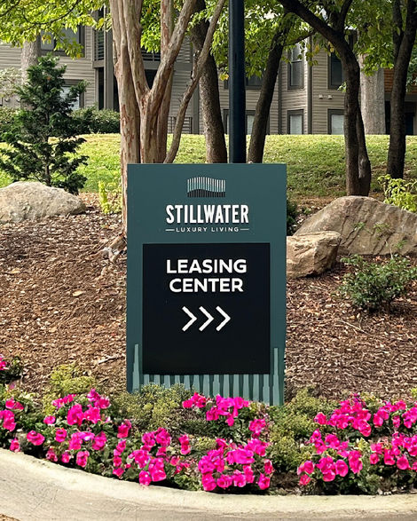Stillwater leasing directional sign with arrows in landscaped setting