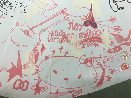 Zoom in of the workshop drawing: Someone has drawn a large image of hello kitty as well as a cat with lazer eyes, surrounded by stars, hearts. Above it they have written "Hello kitty does not speak."