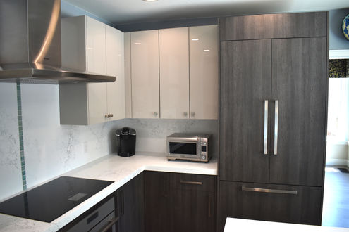 Modern kitchen with white and dark cabinets, a toaster, coffee maker.