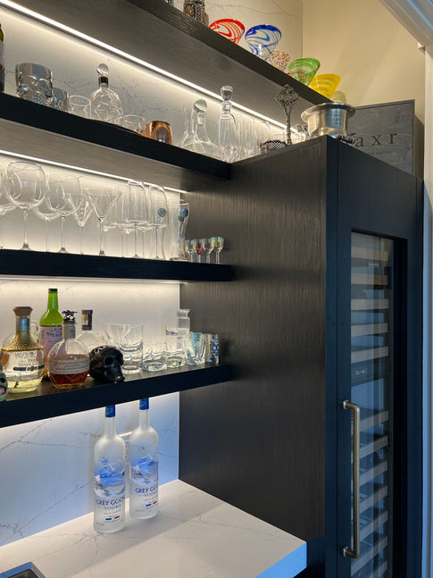 Shelves holding glasses and bottles; wine cooler; illuminated bar. Fissel Bar.