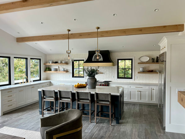 Modern kitchen with island, seating, and overhead lighting, ready for use