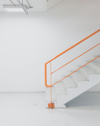 white staircase orange handrail.JPG