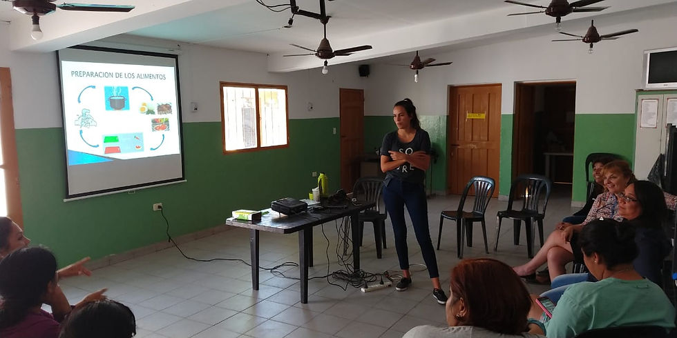 Grupo de mujeres sentadas en ronda escuchando a una jóven