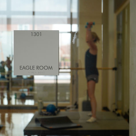 a picture of room sign with girl in background