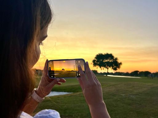 girl taking photo of sunset