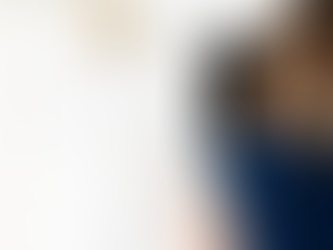 back of a woman sitting at a desk writing