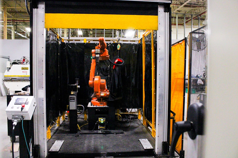 Industrial robotic arm welding inside a secured enclosure with the ATLAS Door engaged.
