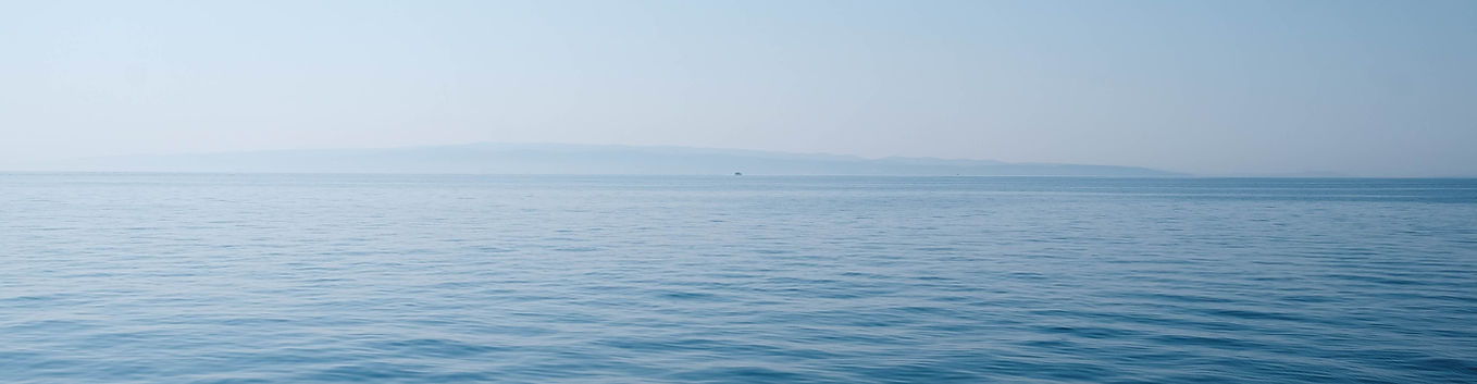 body of water under blue and white sky a