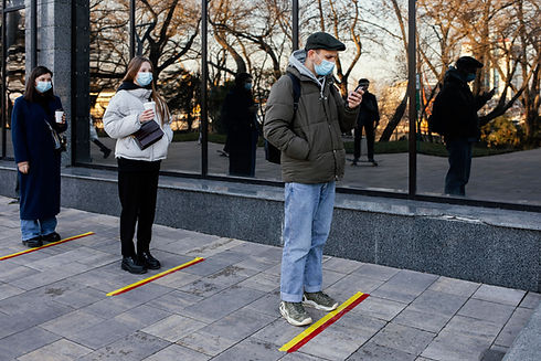 people-in-line-waiting-behind-social-distance-stripe.jpg