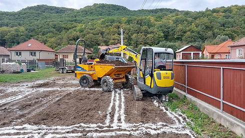 Kirajzolt lakóház alaponn dolgozó markológép földet pakol egy targoncába