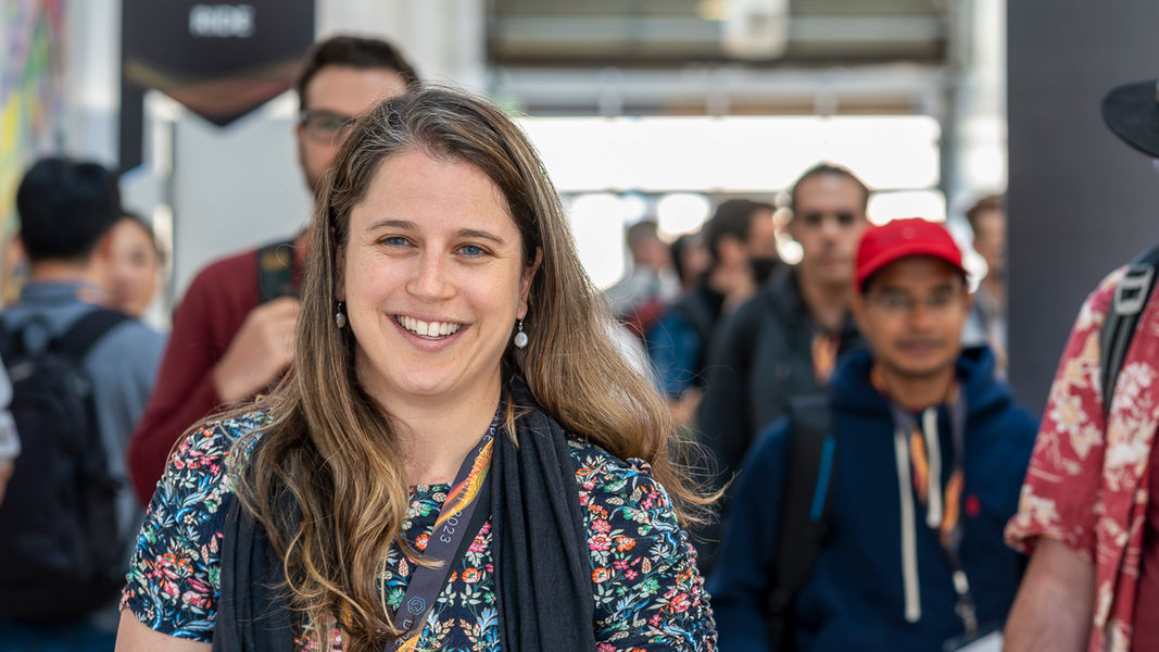 Attendees at the Gradle DPE Summit filing out of a session at The Midway in San Francisco, with a focus on a smiling lady taking a break with her team, capturing the event's engaging atmosphere.