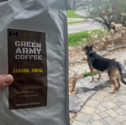 Close-up view of a bag of GREEN ARMY COFFEE beans with a military-style patch beside it