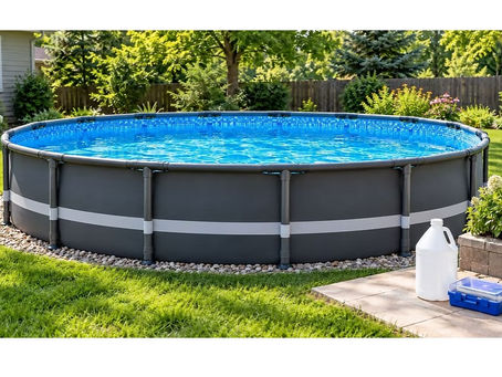 Round above-ground frame swimming pool with dark grey walls, clear blue water, and a white liquid chlorine container beside a closed pool water test kit in a landscaped backyard