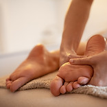 Skilled female masseur giving foot massage to young female__.jpg