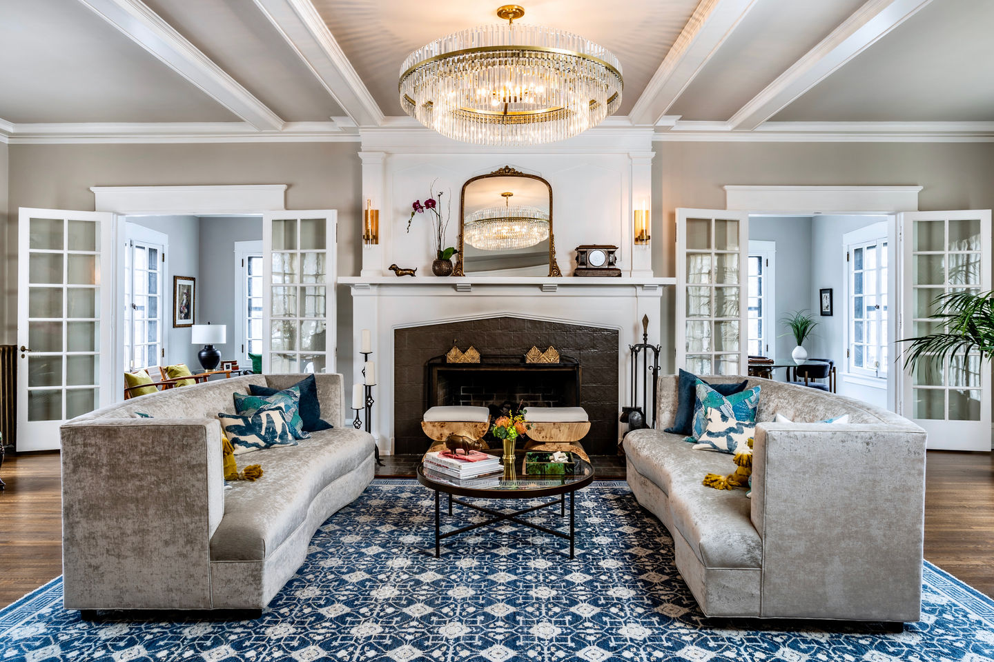 A comfortable, traditional living room with blue and white rugs and a fireplace.