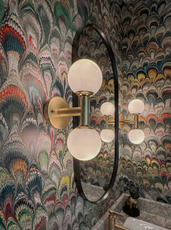 Bold wallpaper design in a powder room and intimate lighting.