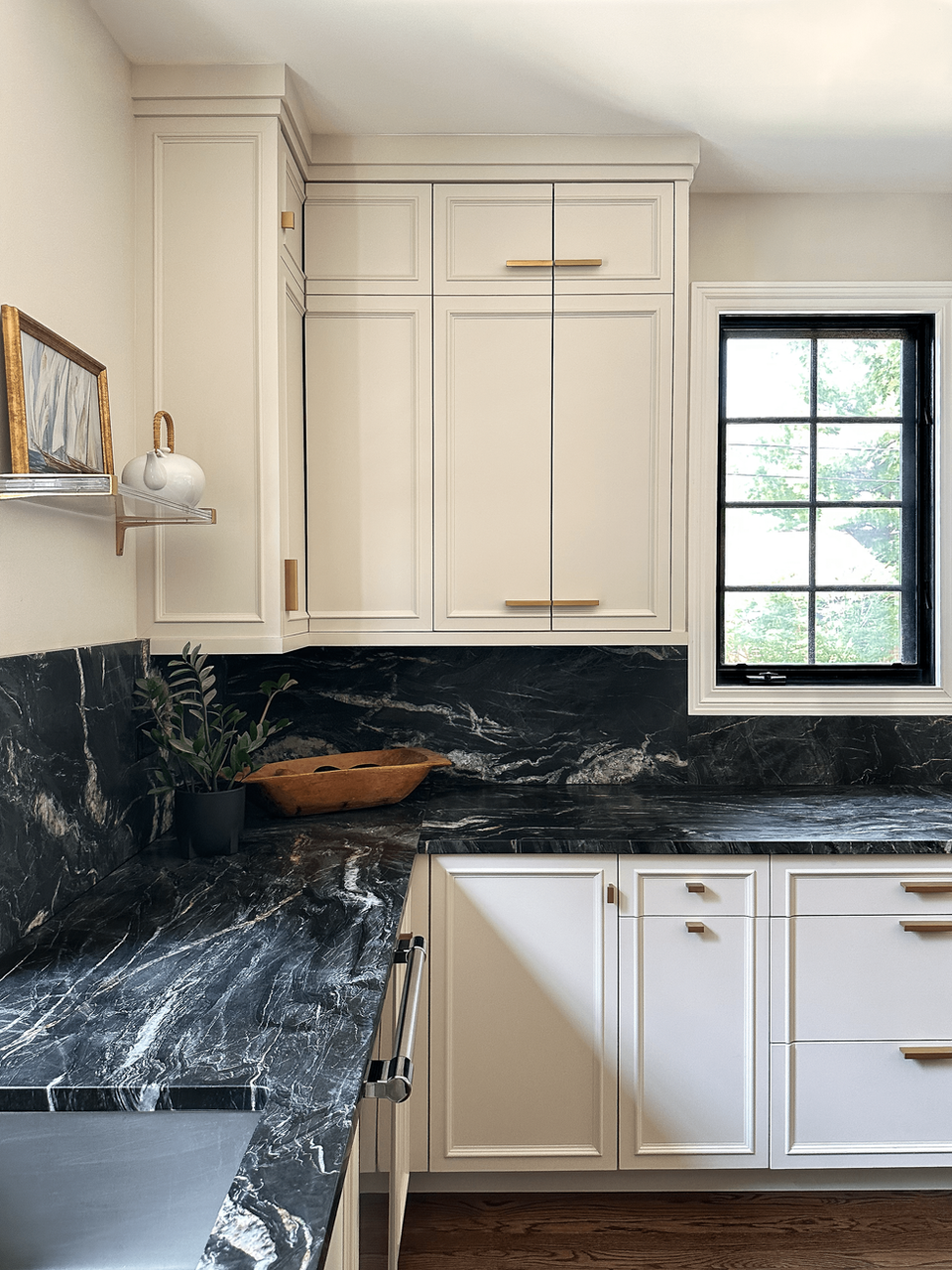kitchen cabinetry with an off-white color and wooden table decor and windows.