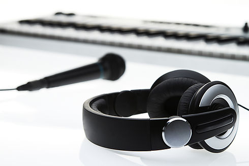 a keyboard our of focus, with a mic and headphones