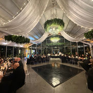 Reception is about to begin and center of attention is on the dance floor.  The ambiance is being set by amber up lighting.  