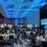 Large convention center room lit with an ambient light blue color for a company Christmas party.