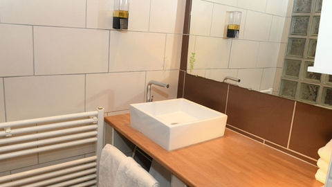 Salle de bain moderne avec douche à l’italienne, située dans un gîte en vieille ville de Colmar