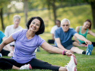 Group of people stretching outdoors illustrating movement, recovery, and healthy body function