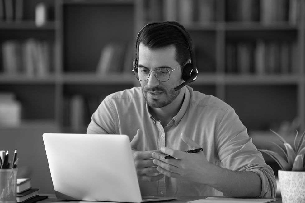 A man working from home on a laptop, midway through a video call