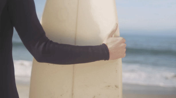 GIF of a surfer walking toward the ocean.