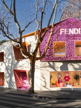 Pop-up da Fendi em Xangai com fachada rosa e roxa revestida de lantejoulas, integrada à paisagem urbana da rua.