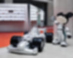 Instalação cenográfica em loja da Gentle Monster com escultura inflável de carro de corrida e personagem inspirado em Mickey, parte de experiência imersiva da marca.