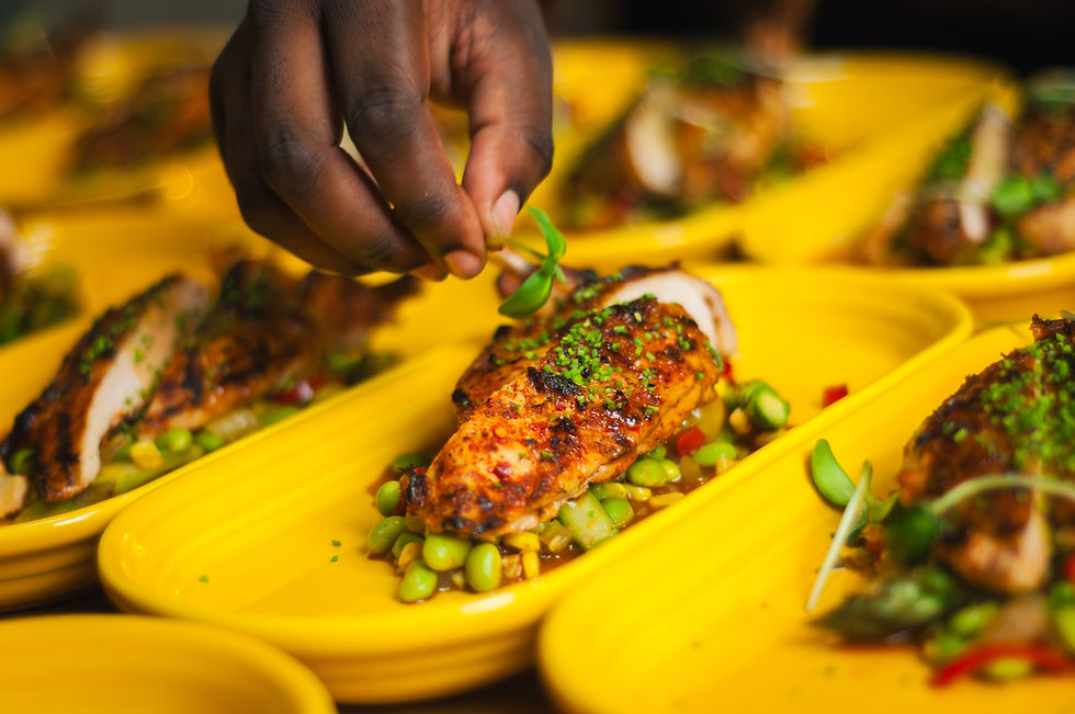 A chef placing a garnish on a dish.